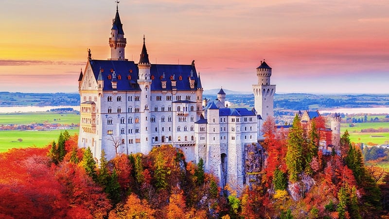 Germany. Famous Neuschwanstein Castle In The Background Of Trees