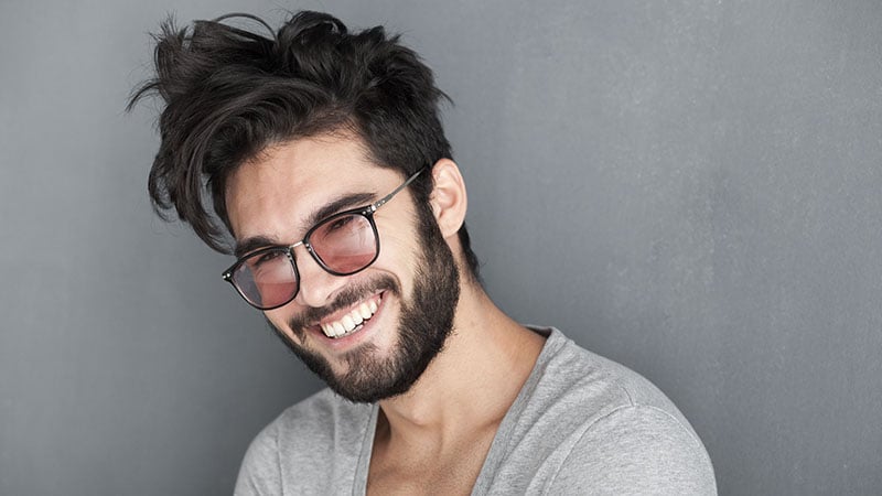 Sexy Man With Beard Smiling Big Against Wall