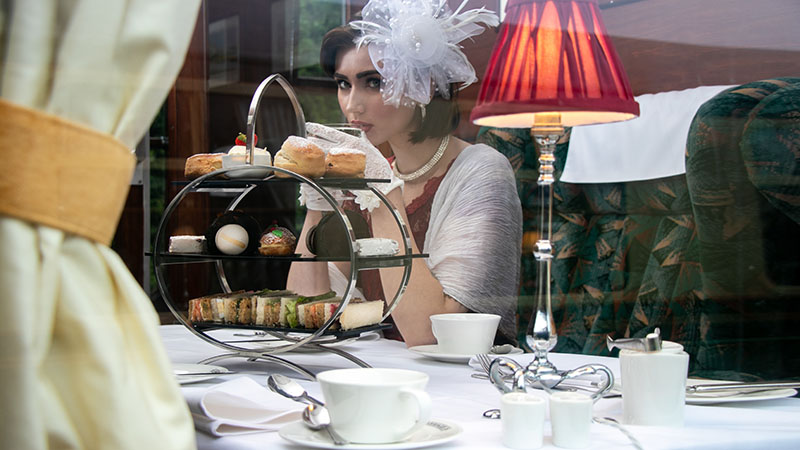 Beautiful Woman In Vintage Clothing Enjoying Afternoon Tea In Train Carriage