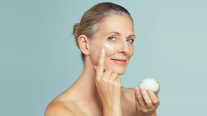 Mature Woman Applying Skin Cream On Face