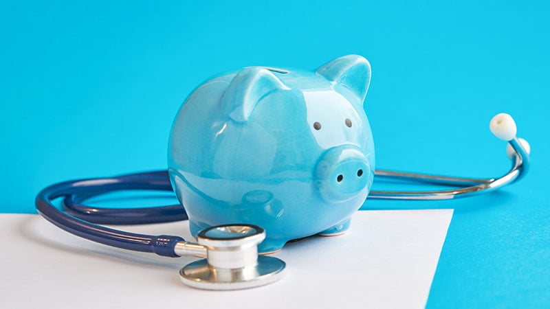 Piggy Bank With Stethoscope Isolated On Blue Background. Concept Of Financial Literacy. Creating And Maintaining A Budget. Keeping Their Finances On Track. Ruin Loan History