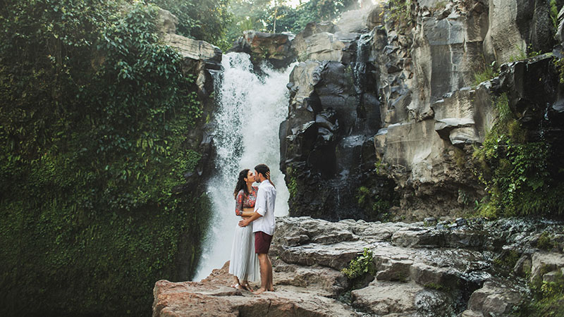 Jeune couple s'embrassant avec vue cascade. Heureux ensemble, lune de miel à Bali