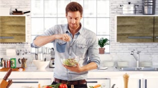 Handsome Man Cooking At Home Preparing Salad In Kitchen.