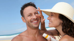 Woman Putting Sunblock On Her Boyfriend's Nose