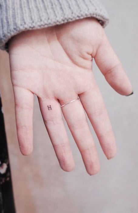 Letters R and T tattooed on the fingers