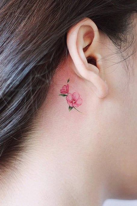 Minimalistic heart tattoo placed behind the ear