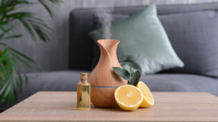 Aroma Oil Diffuser And Citrus Fruit On Table In Room