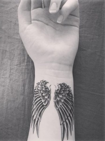 Angel wings tattoo  Wrist tattoos for guys Small forearm tattoos Wing  tattoos on wrist