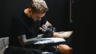 Professional Tattoo Artist Working In His Tattoo Studio.