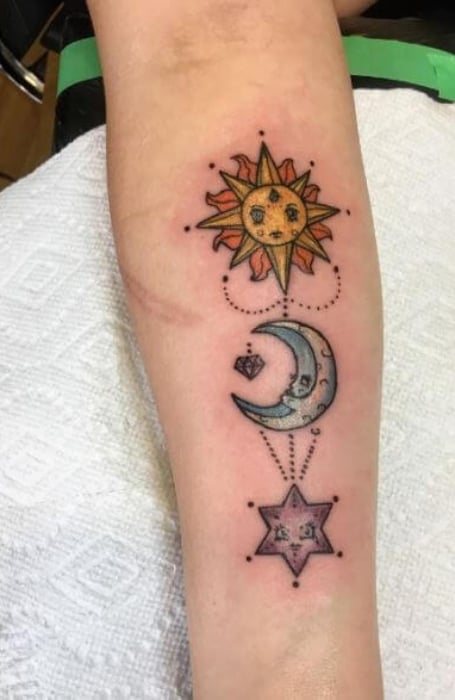 Ornamental moon and stars tattoo located on the