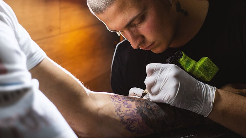 Tattoo Artist Making A Tattoo On A Hand In Tattoo Studio